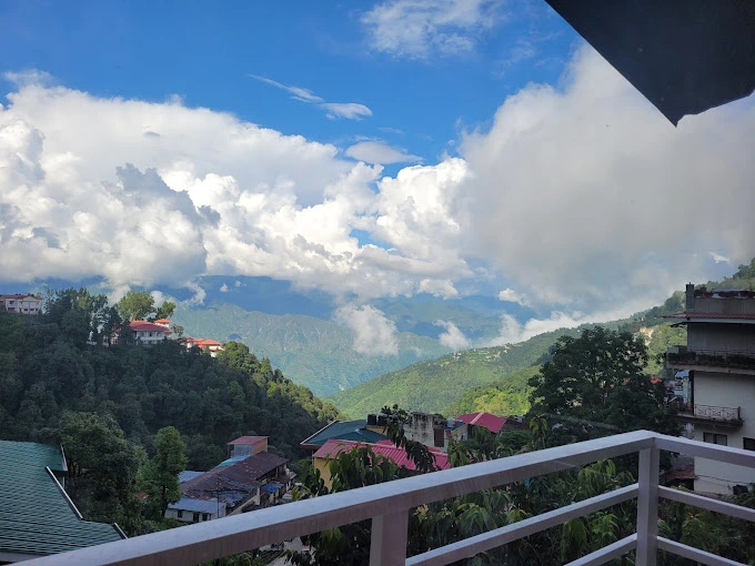 The balcony view from Hotel Dwaper, offering a stunning vista of the majestic Mussoorie mountains.