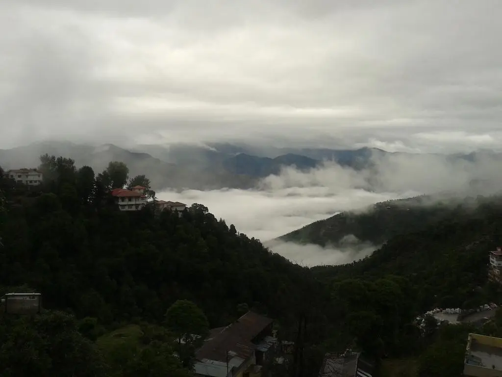 Breathtaking view of the mountains in Mussoorie from Hotel Dwaper, with lush greenery and rolling hills stretching into the distance.