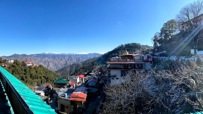 Breathtaking view of the mountains from the balcony of Hotel Dwaper, with lush greenery and clear blue skies.